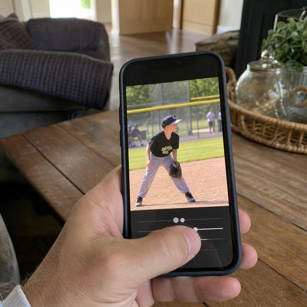 A phone showing a sports photo being adjusted